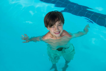 Smiling boy swimming in the pool