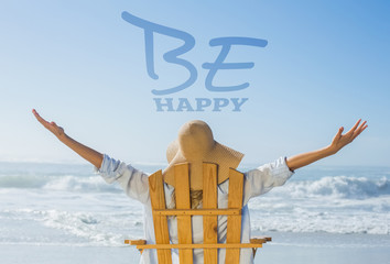 Woman relaxing in deck chair by the sea against be happy