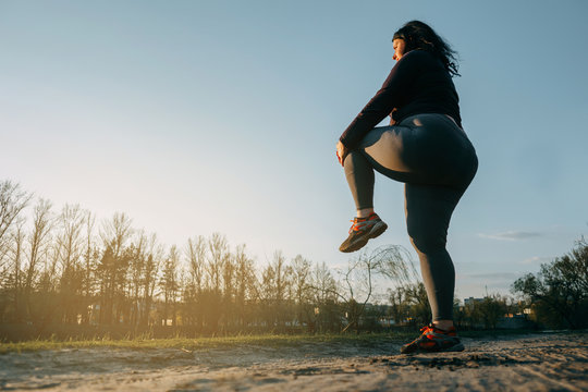 Woman warming up legs before outdoor running