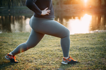 Overweight woman training legs before jogging
