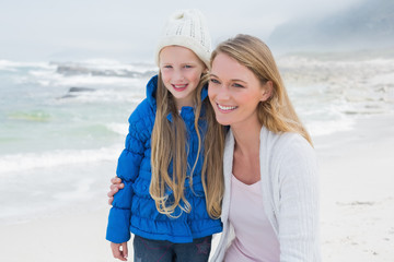 Cute girl with smiling mother at beach