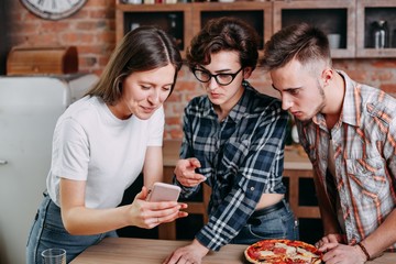 Three young people sitting around, having fun and taking picture