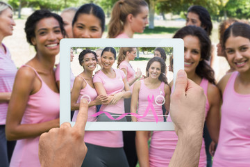 Composite image of hand holding device showing photograph of breast cancer activists