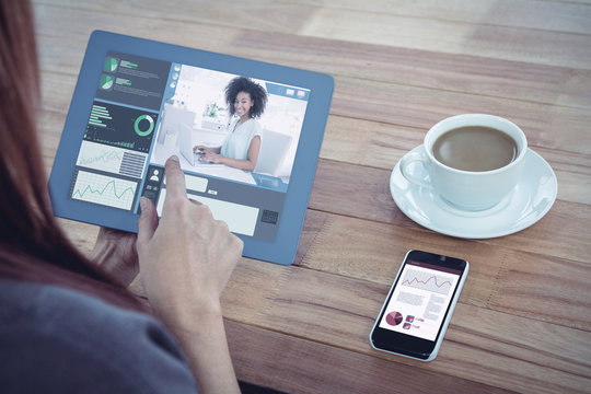 Happy businesswoman working on her laptop against over shoulder view of hipster woman using tablet