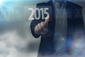 Businessman standing and pointing against 2015 on interface