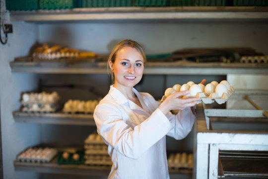 Woman packing hen eggs in farmhouse.