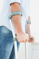 Closeup mid section of a young man with crutches