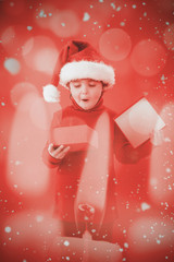 Festive little boy opening a gift against candle burning against festive background