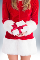 Sexy santa girl holding gift on vignette background