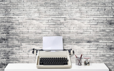 Mock up: Workspace desk with typewriter on white table with old brick wall