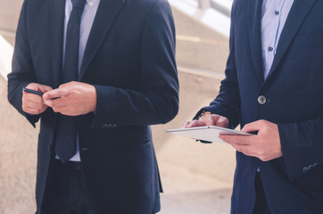 two attractive business man using touching pad on smartphone and tablet technology connecting social online.