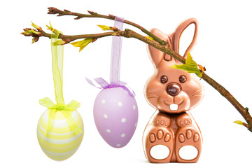 Hanging easter eggs against cute chocolate bunny