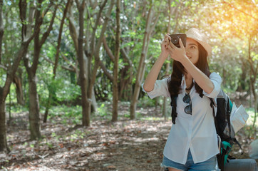 attractive woman adventure hiker go to trekking in the forest sightseeing natural at holiday travel concept. photographer using camera take a photo.