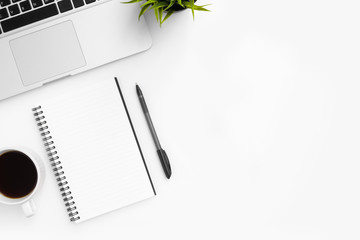 White office desk table with blank notebook, pen and cup of coffee. Top view with copy space, flay lay.