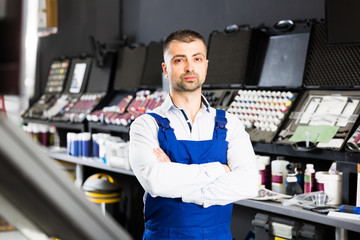 Naklejka na ściany i meble Auto mechanic standing with crossed arms