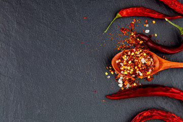 Red and yellow chili pepper dried. On a stone black background. - 202724280
