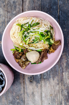 Thai style dry beef noodle on wooden table
