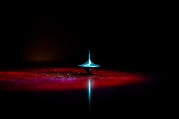 Totem spinning top spinning, wobbling and stopping. Spinning top on mirror surface with toned smoke...