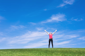 Young woman standing in field of green grass