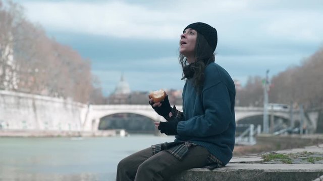 lonely young female beggar alone eating an apple- marginalization,poverty,hunger