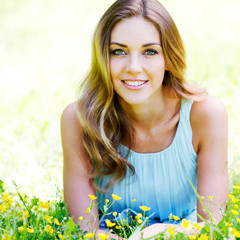 young woman in blue dress lying on grass