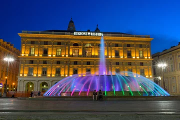 Photo sur Plexiglas Fontaine GENOA (GENOVA), ITALY, APRIL 16, 2018 - View of the colorful fountain and Palace of the Liguria region of De Ferrari Square by night in Genoa, the heart of the city, Italy.