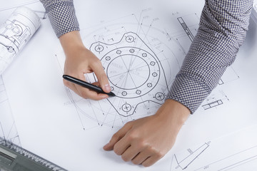 Engineer/ architect workplace. Top view on man / male hands making mechanical / architectural sketches of turbine with a pen and ruler.