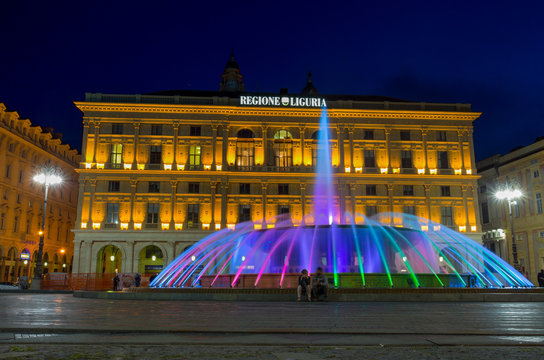 GENOA (GENOVA), ITALY, APRIL 16, 2018 - View of the colorful fountain and Palace of the Liguria region of De Ferrari Square by night in Genoa, the heart of the city, Italy.