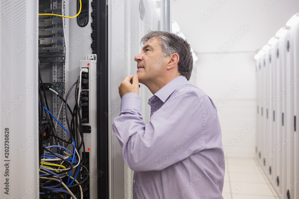 Poster Man looking up thoughtfully into server locker