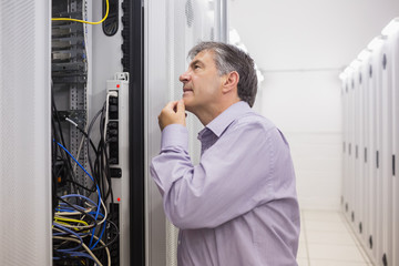 Fototapeta premium Man looking up thoughtfully into server locker