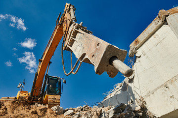 excavator loader machine at demolition with hydrohammer on construction site