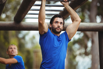 Fit man climbing monkey bars