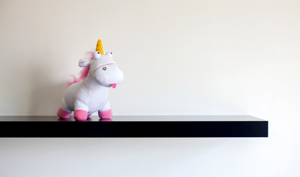 Stuffed unicorn standing on a shelf