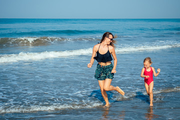 mother and daughter playing catch-up on the beach