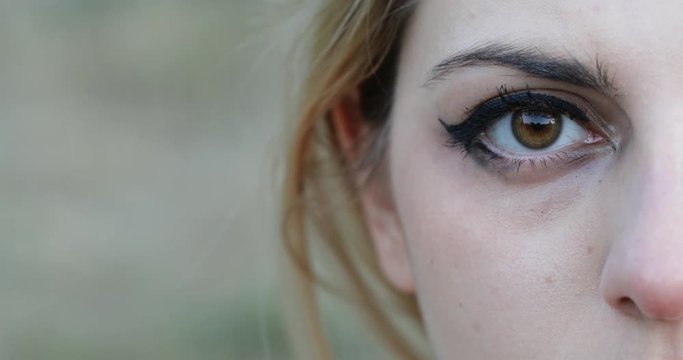 young woman open eye staring camera- close up