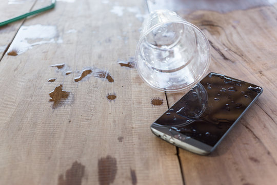 Glass Of Water Spilled On A Mobile Phone,