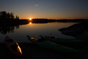 Kayaks by the shore in a quiet brook at dawn