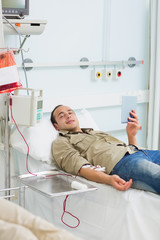 Male transfused holding a tablet computer