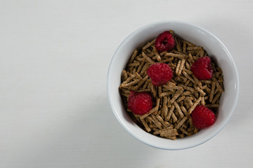 Bowl of cereal bran stick and raspberries