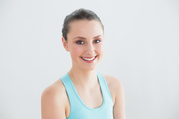 Close up of smiling toned woman against wall