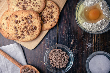 Chocolate cookies on wooden table with flour eggs and ingredients