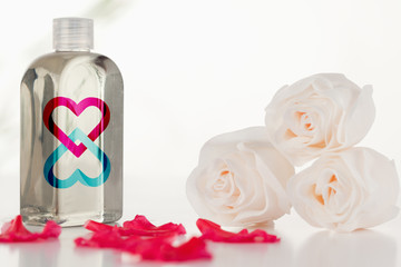 Linking hearts against glass flask with petals and roses