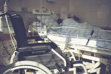 Wheelchair in the medical ward near the bed with the patient