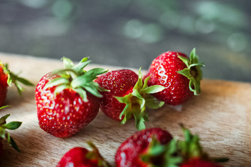 Ripe juicy beautiful red strawberry on a wooden dark background closeup