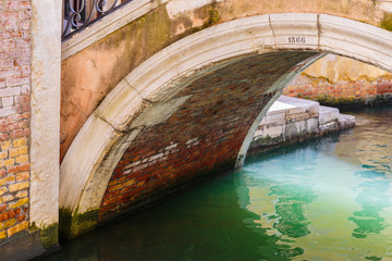 Fototapeta na wymiar Bridge over a narrow canal in Venice