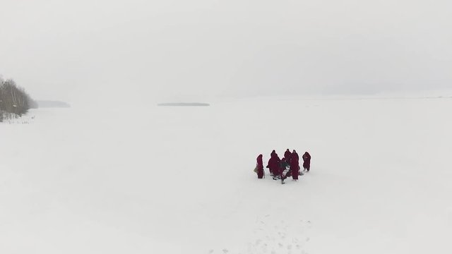 A group of people traveling on the taiga or snow-covered forest follow each other. Footage. Group of some people on winter hike in mountains, backpackers walking on snowy forest