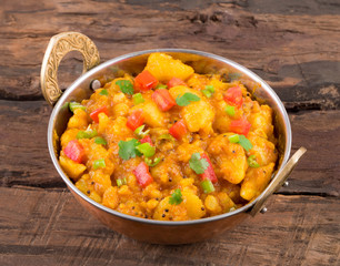 Indian Cuisine Spicy Fried Aloo Also Know as Potato Fry, Potato Curry, Aloo Masala or Alu Masala on Wooden Table