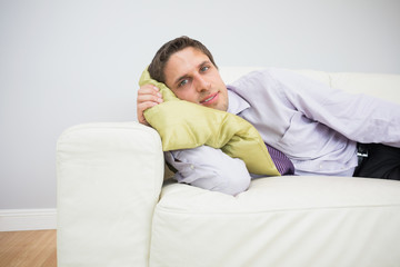 Fototapeta premium Portrait of a businessman lying on sofa in living room
