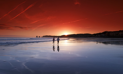 Runners and dog reflection in Basque coast