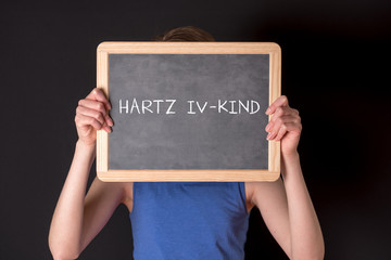 Ein Kind mit einem Schild Hartz IV Kind